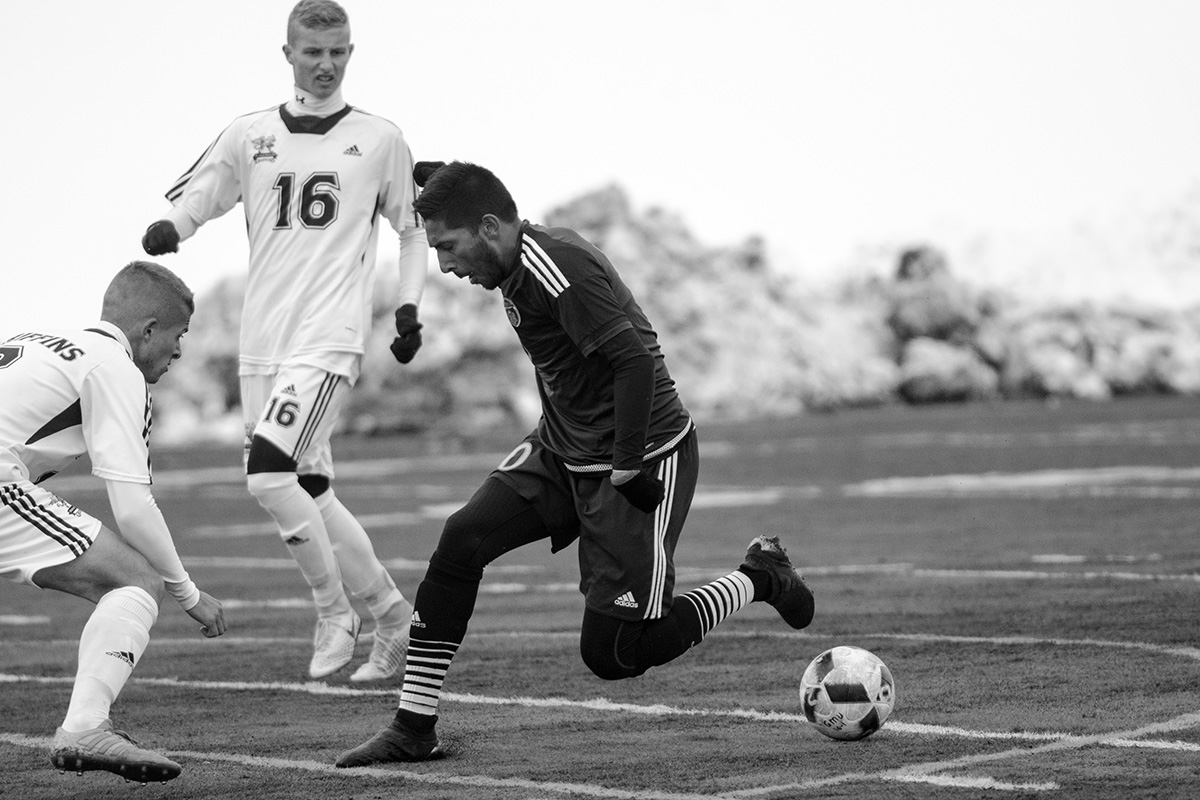 Sarkaria dekes through the MacEwan defense.