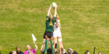 Panda and Dino player get hoisted into the air by teammates to reach the rugby ball